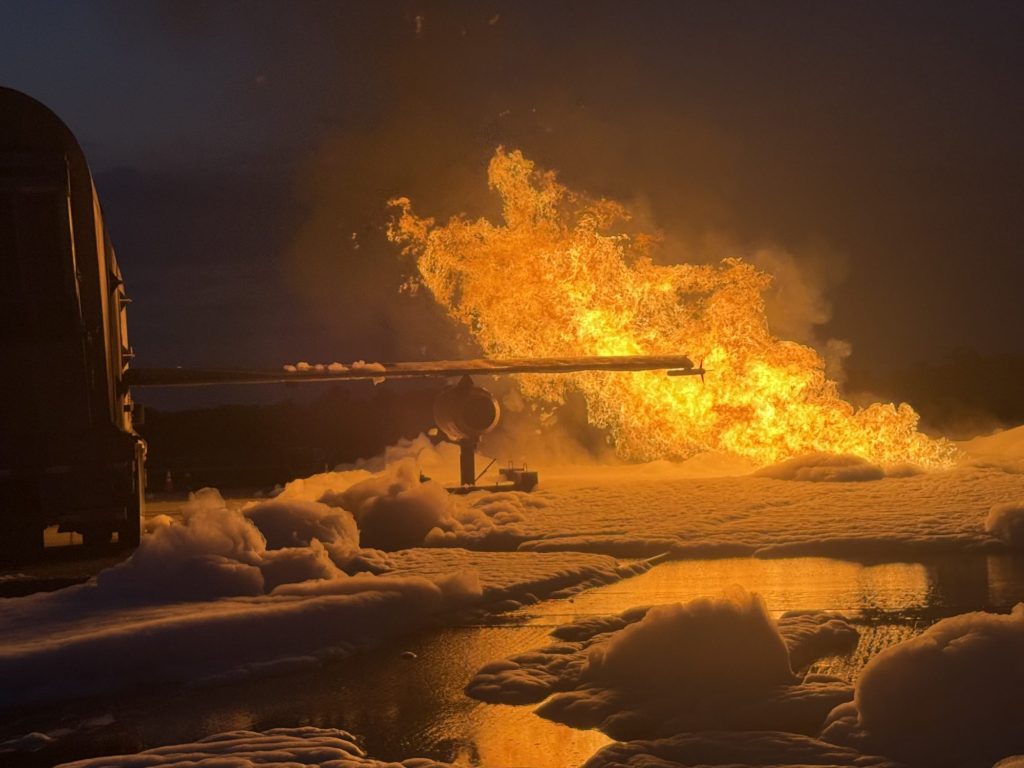 Aircraft wing fire over a foam blanket at night