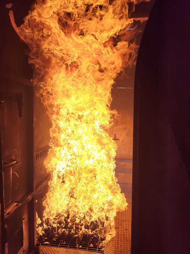 Flames rolling inside an ARFF interior fire trainer