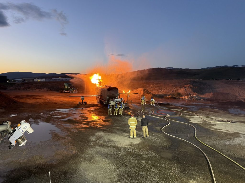 Crews staged on an ARFF training ground during a burn at dusk