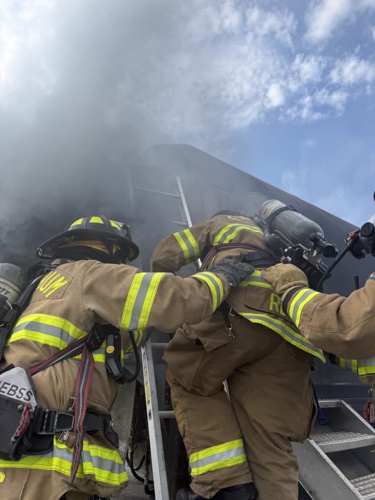 Firefighters climbing aircraft stairs during an interior attack drill