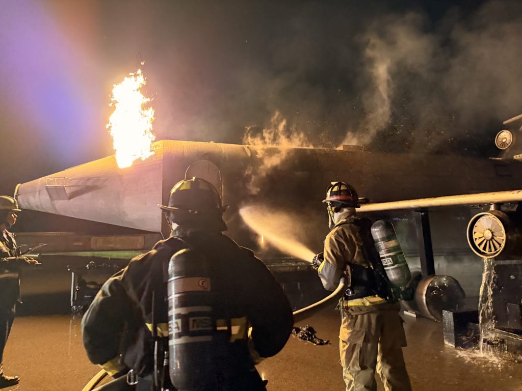 Hose team attacking an aircraft fire at night