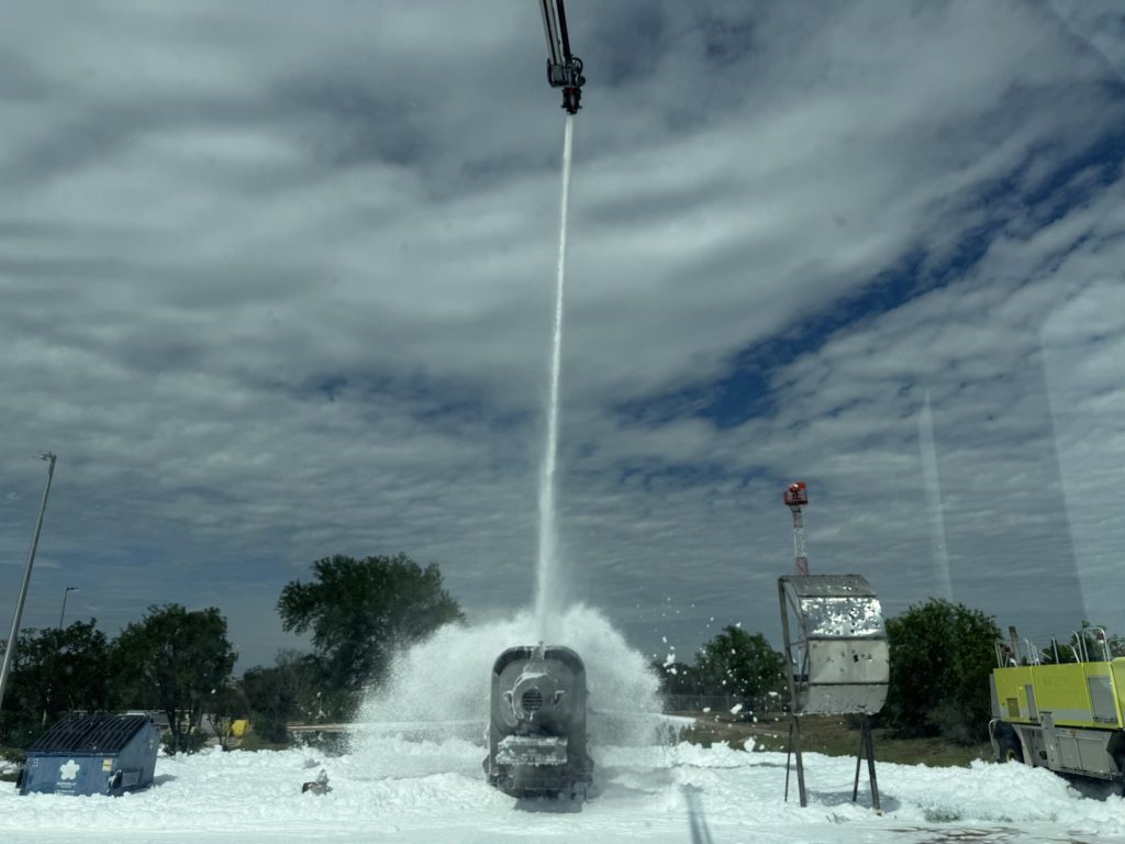 High-reach turret blanketing the aircraft fire trainer in foam