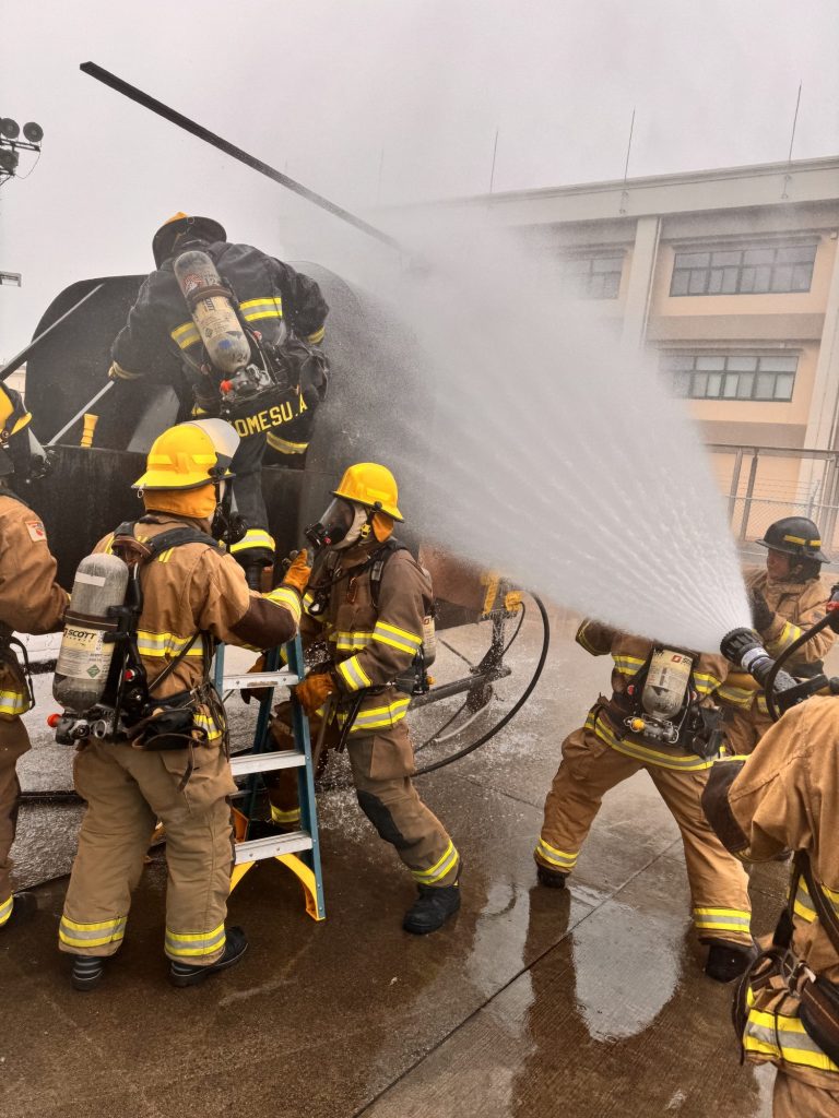 Hose teams attacking an aircraft fire trainer